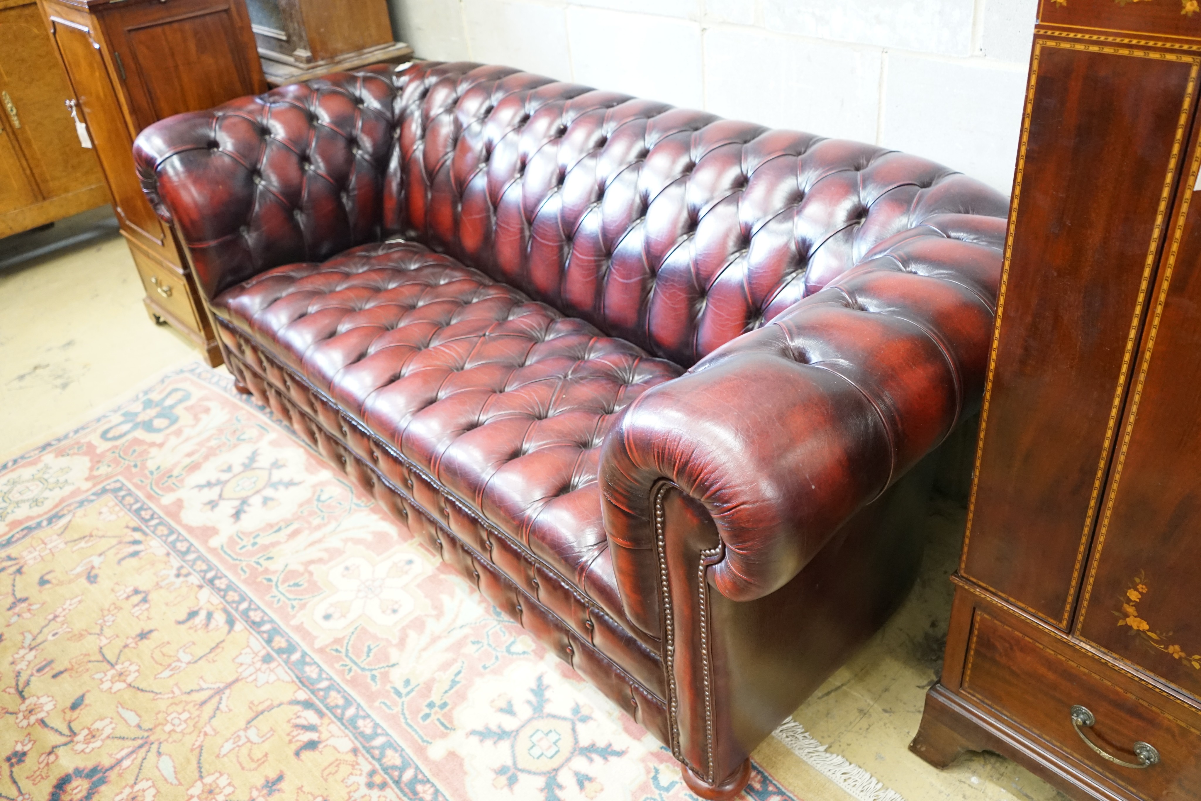 A Victorian style buttoned burgundy leather Chesterfield settee, length 200cm, width 90cm, height 74cm